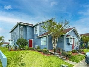 a blue house with a red door and a green yard