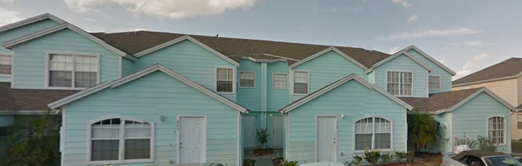 a row of blue houses with a car parked in front of them