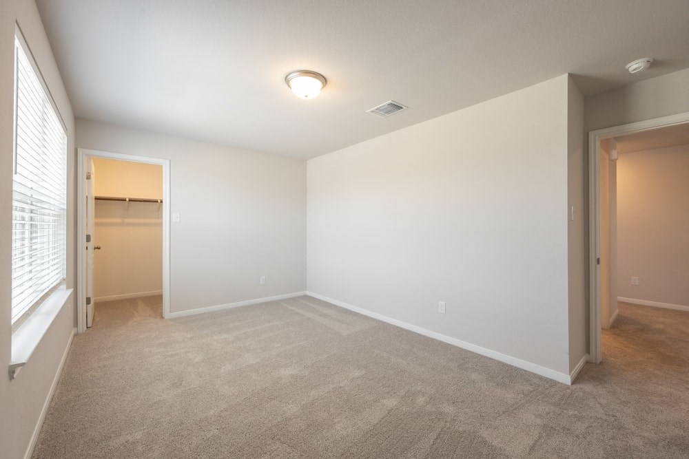 an empty living room with a door to a closet and a window