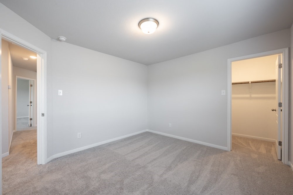 the living room of an empty house with a door to a closet