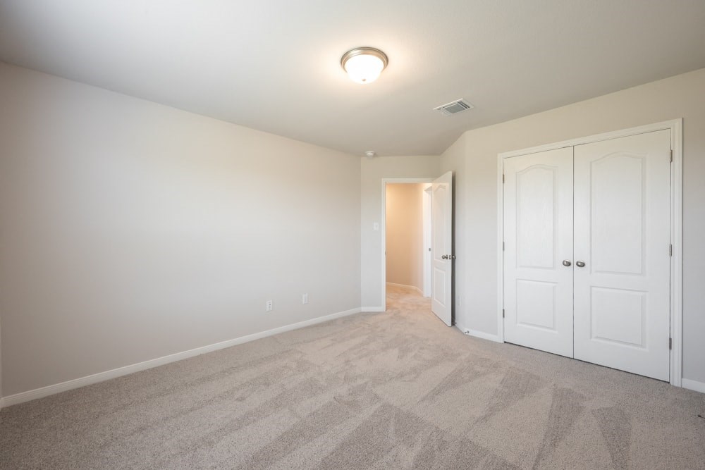 a bedroom with two closets and a door to a hallway
