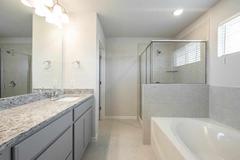 a bathroom with a tub and a sink and a shower