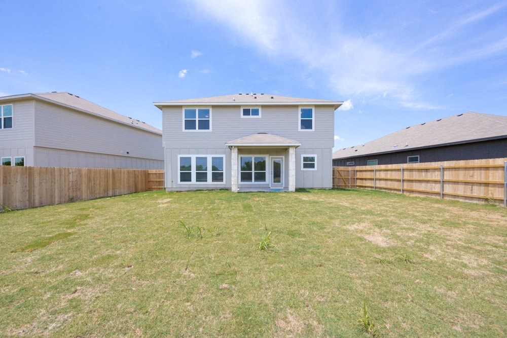 a backyard with a house and a fence