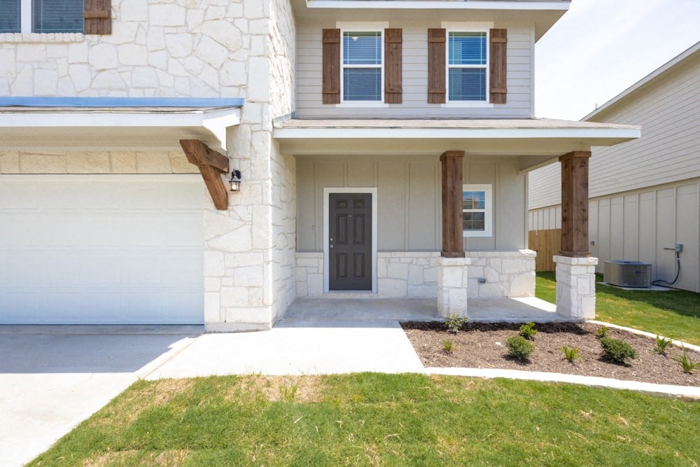 a white house with a black door and a porch