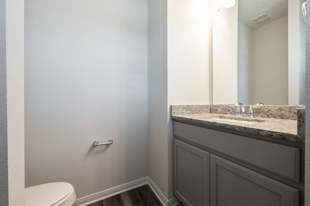 a bathroom with a toilet and a sink and a mirror