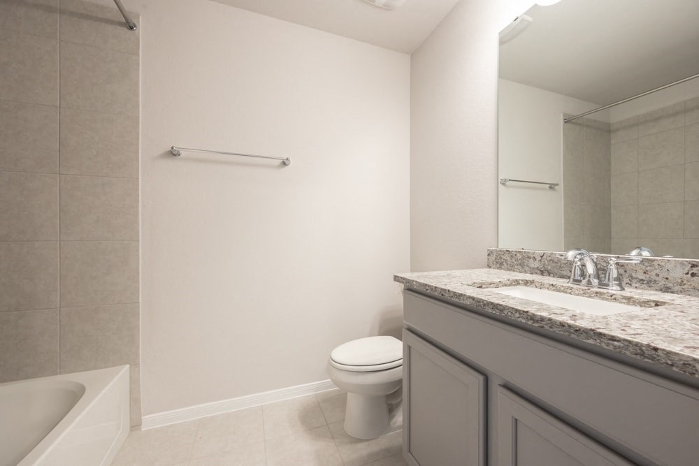 a bathroom with a toilet and a sink and a mirror