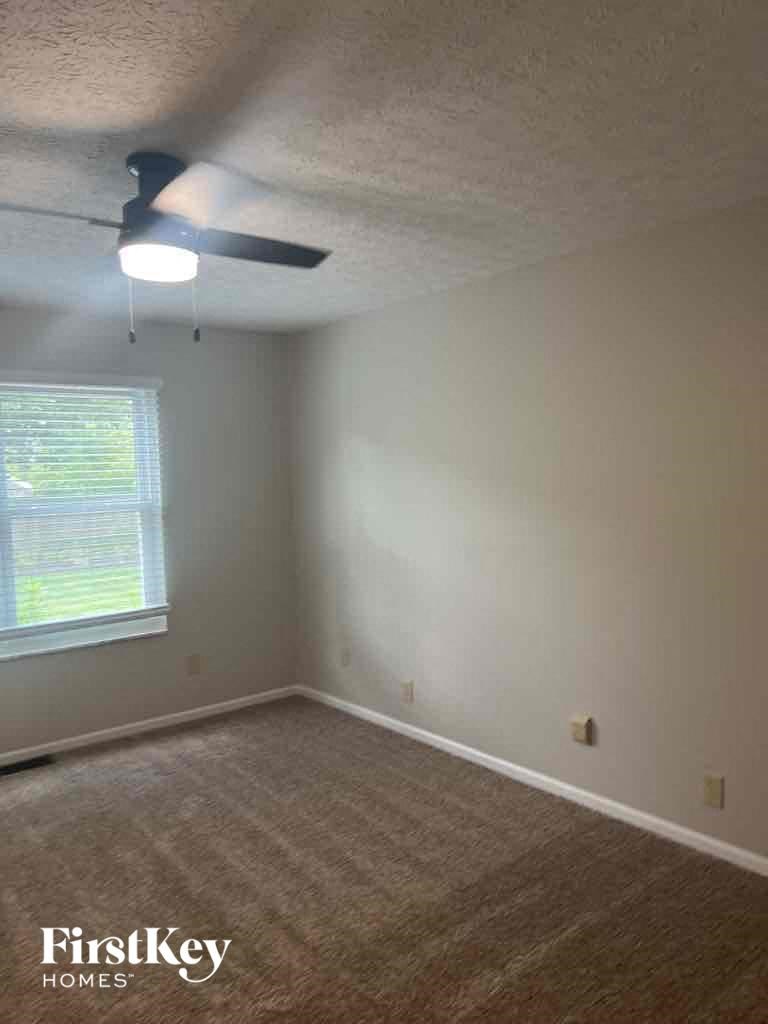 an empty room with a ceiling fan and a window