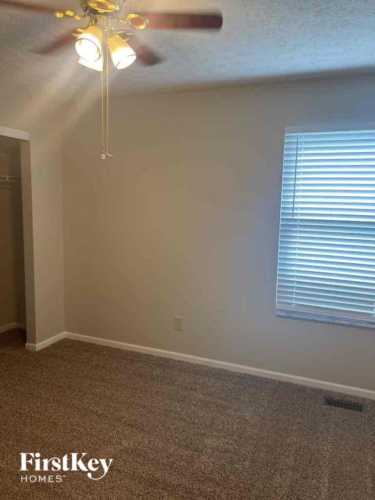 a empty room with a ceiling fan and a window