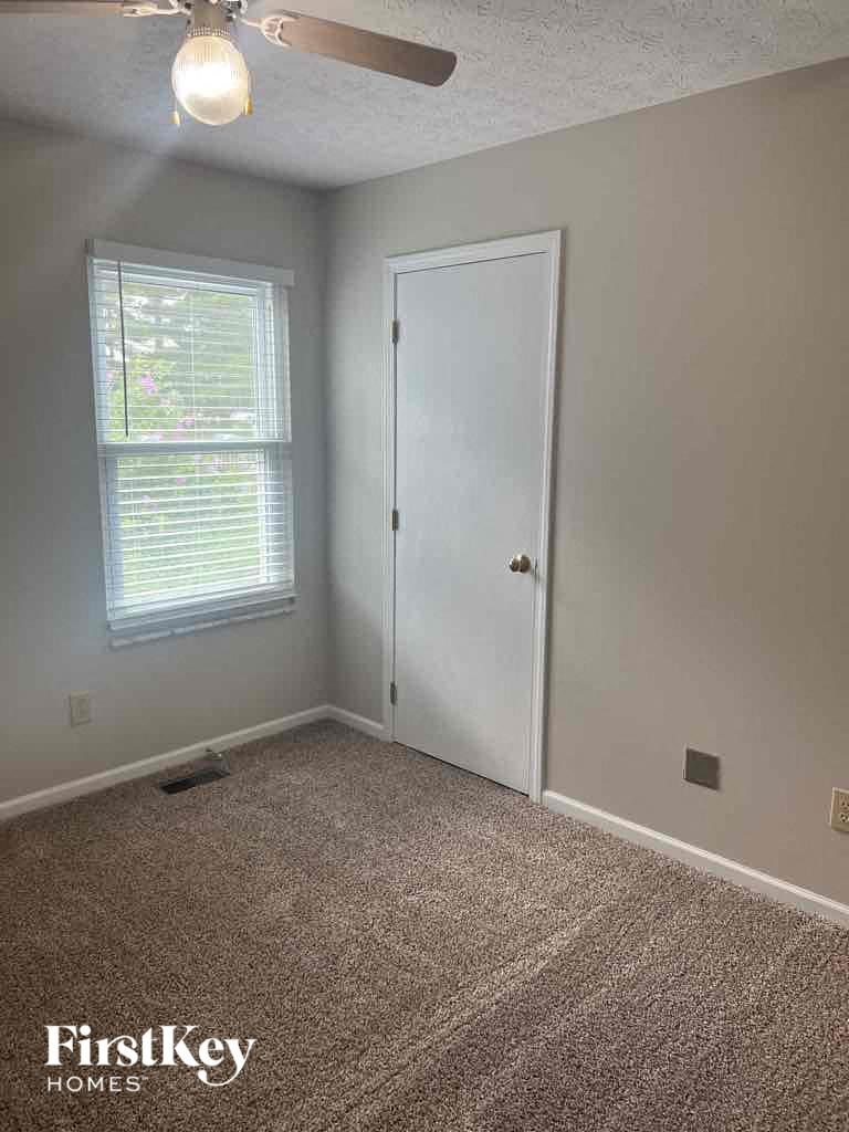 an empty room with a white door and a window