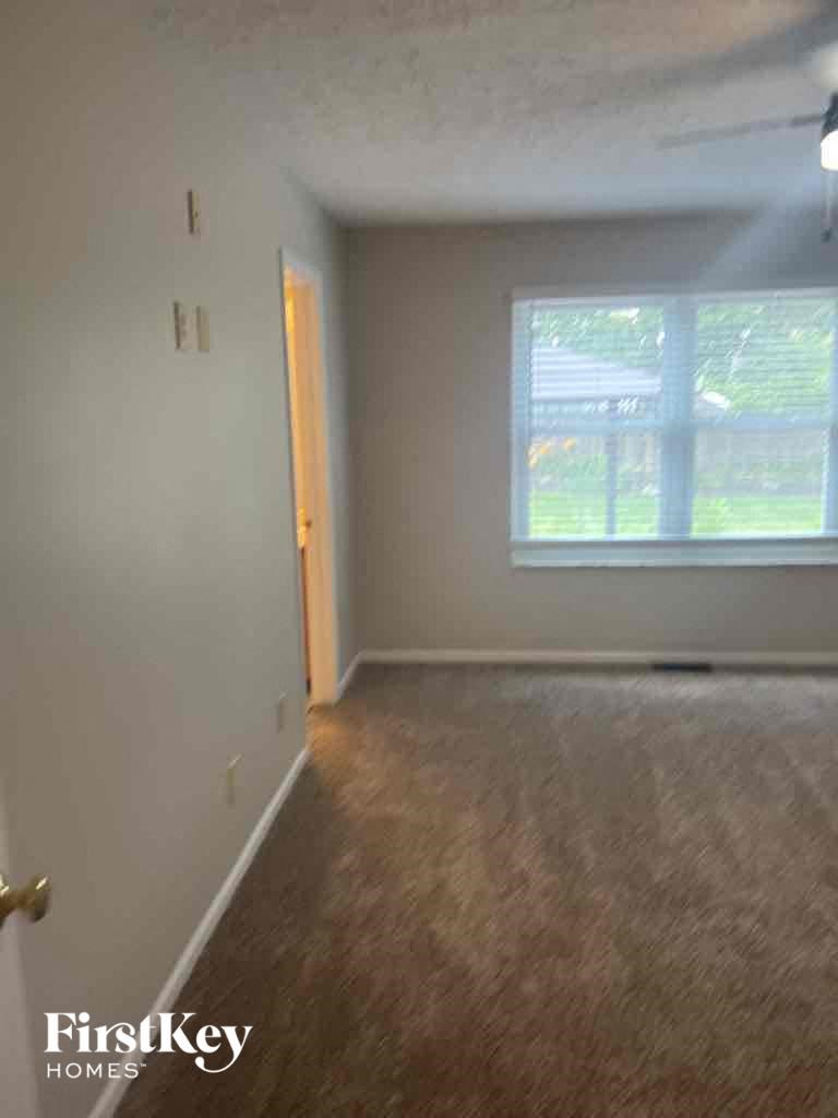 an empty living room with a window and a door