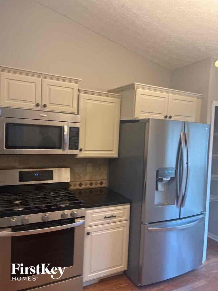a kitchen with stainless steel appliances and white cabinets