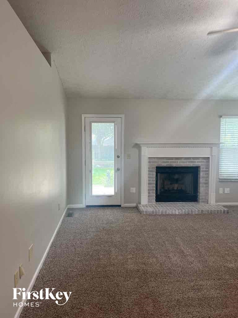 an empty living room with a fireplace and a door