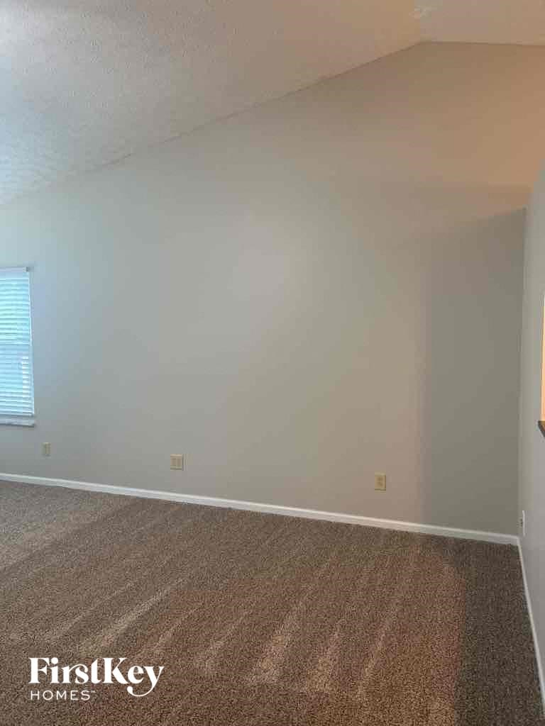 an empty living room with white walls and a carpet