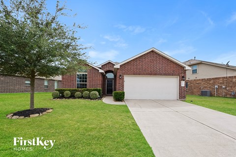 a brick house with a white garage door and a lawn