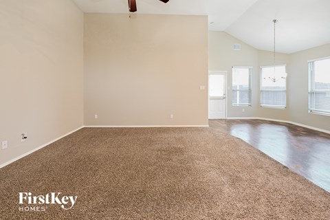 an empty living room with a carpeted floor
