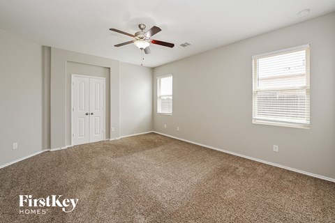 the master bedroom has a ceiling fan and carpeted flooring