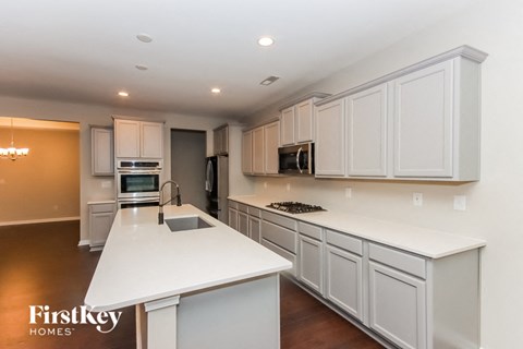 A modern kitchen with white cabinets and a white island.