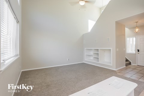 an empty living room with a white wall and a window