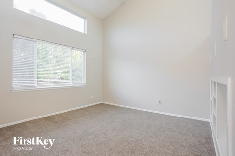 a bedroom with a large window and a carpeted floor