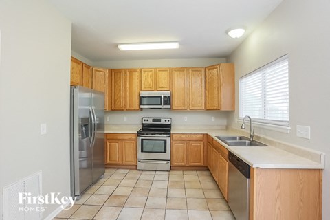 a kitchen with wooden cabinets and stainless steel appliances