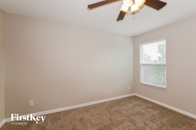a bedroom with a ceiling fan and a window