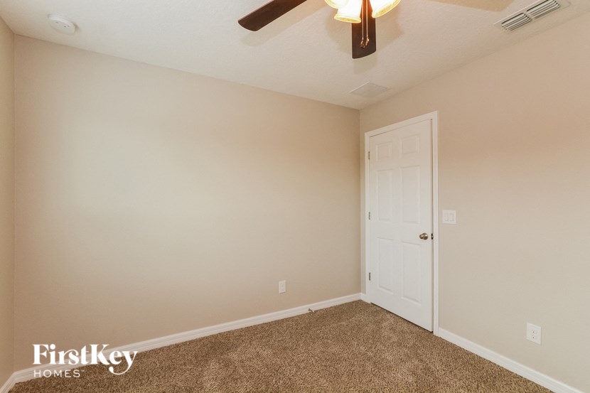 a bedroom with a ceiling fan and a white door