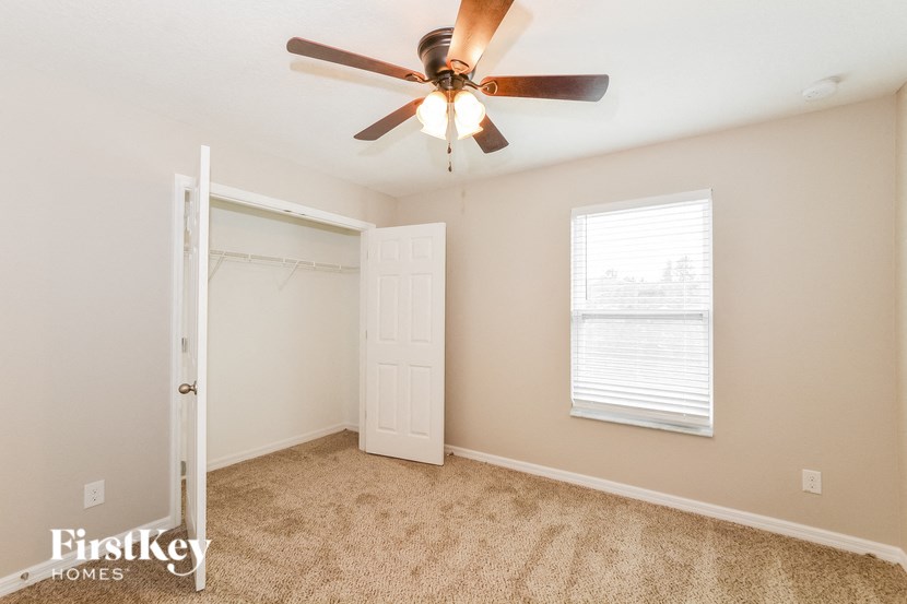 a bedroom with a ceiling fan and a closet