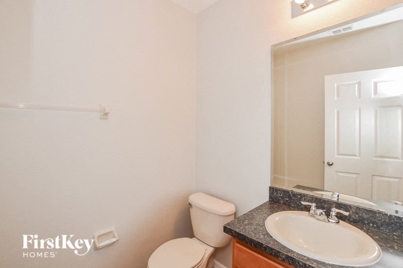 a bathroom with a sink toilet and a mirror