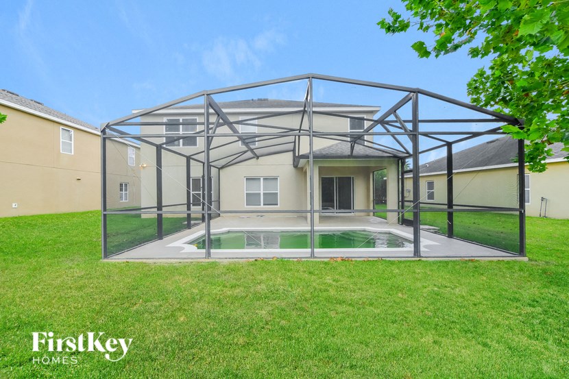 a glass house with a pool in the grass