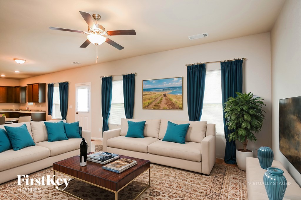 A living room with a white couch, a coffee table, and a ceiling fan.
