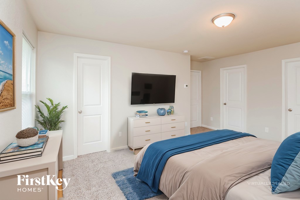 A bedroom with a bed, dresser, and a painting on the wall.