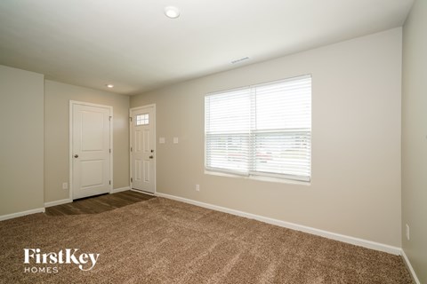 A room with two doors and a window with blinds.