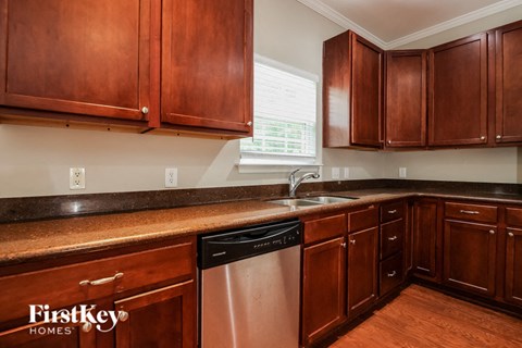 A kitchen with wooden cabinets and a stainless steel dishwasher.