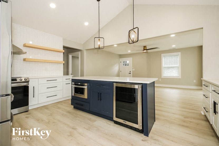 a large kitchen with a blue island and white cabinets
