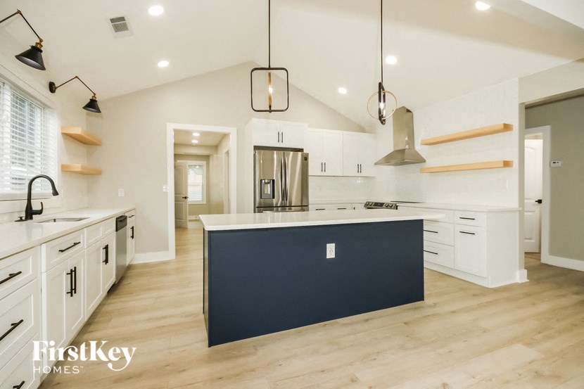 a large kitchen with white cabinets and a black island