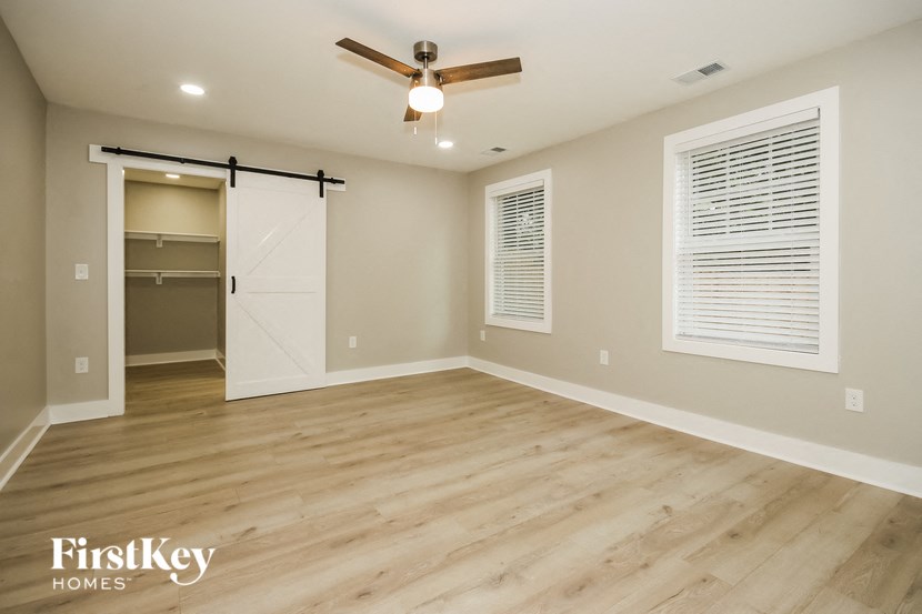 an empty living room with a closet and a ceiling fan
