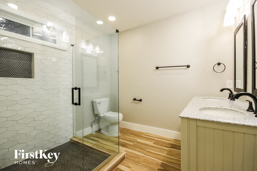 a bathroom with a shower and a sink and a toilet