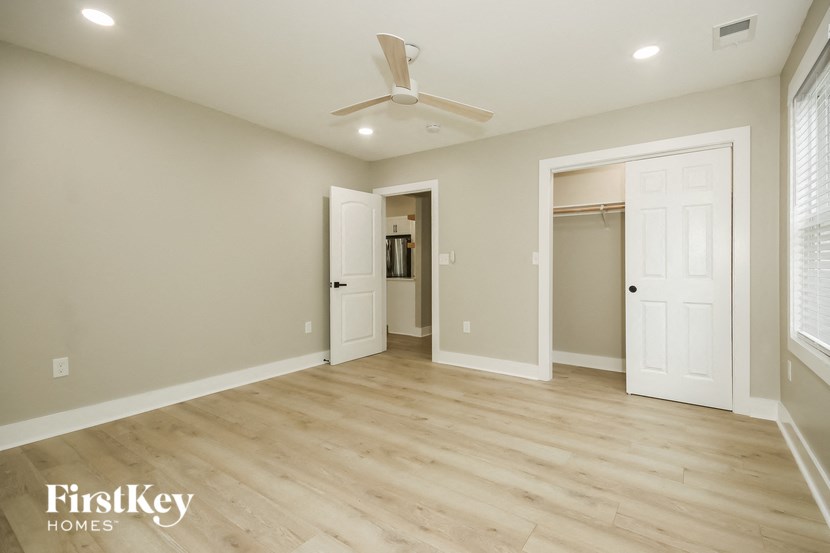 a living room with wood floors and a ceiling fan
