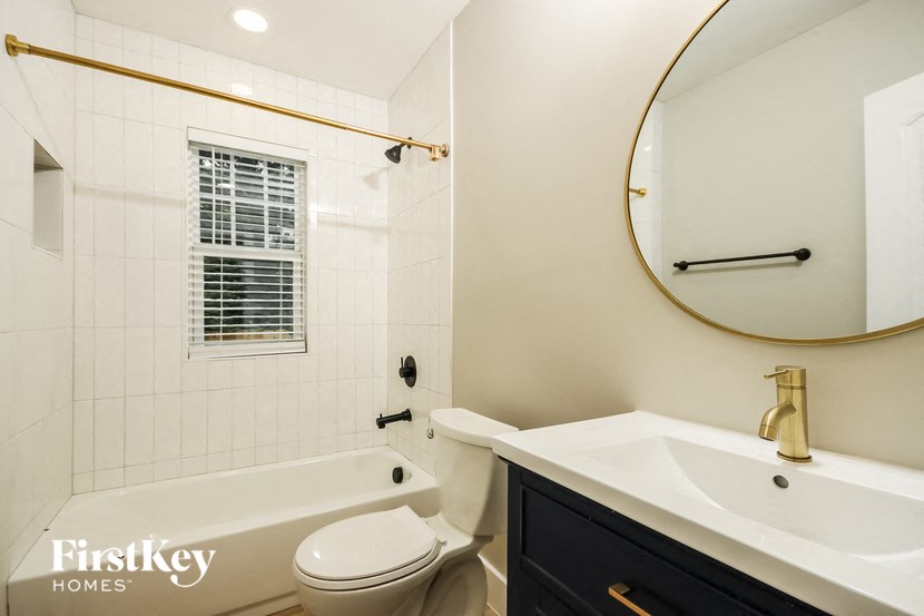 a bathroom with a toilet sink and tub and a mirror