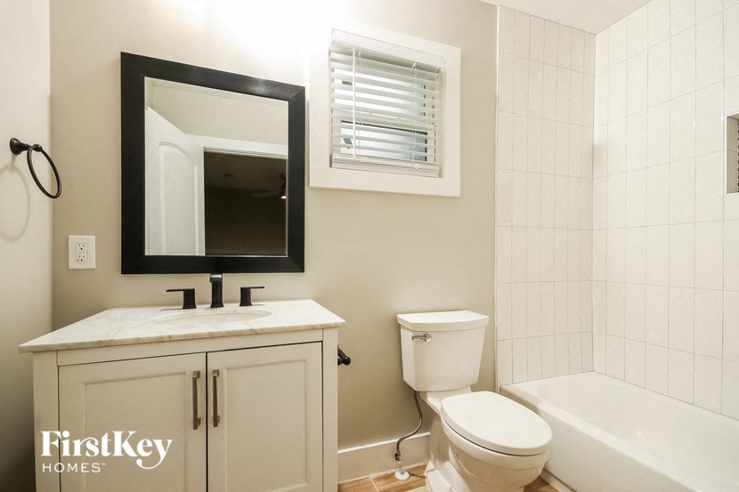 a bathroom with a toilet and a sink and a bath tub