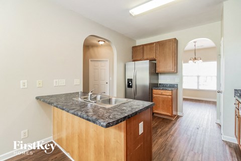 A kitchen with wooden cabinets and a granite countertop.
