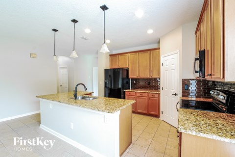 A kitchen with granite countertops and wooden cabinets.