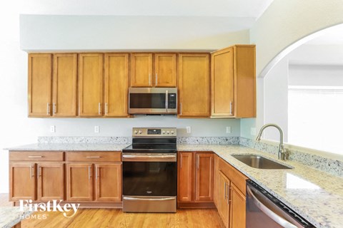 a kitchen with wooden cabinets and stainless steel appliances and granite counter tops