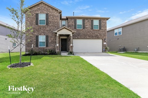 a large brick house with a white sidewalk in front of it