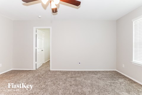 a bedroom with a carpeted floor and a ceiling fan