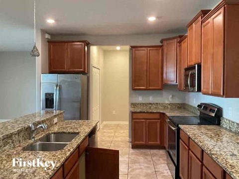 A kitchen with brown cabinets and granite countertops.