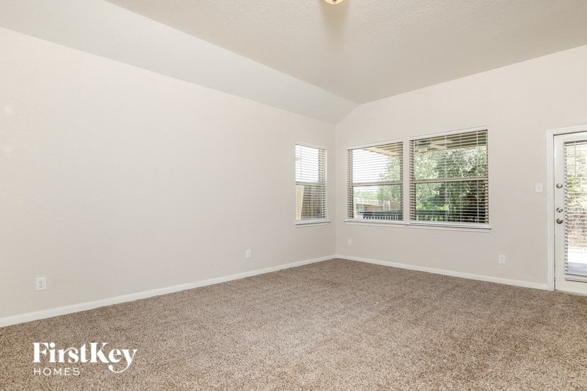 the living room of a home with carpet and a window
