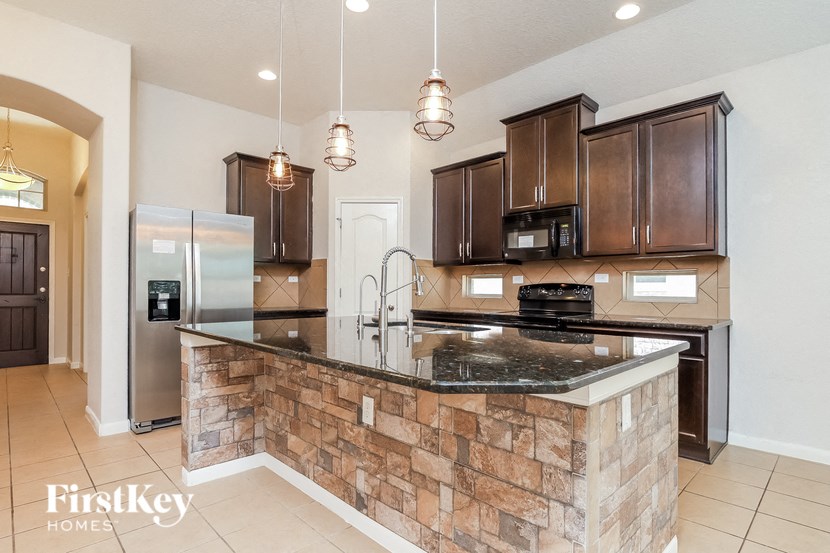 a kitchen with a large island with a granite counter top