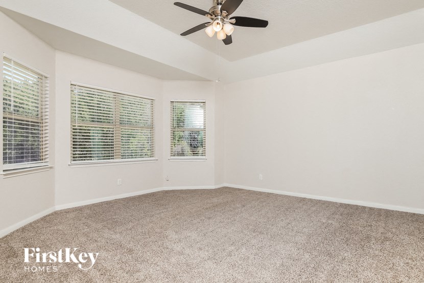 the living room of an empty house with a ceiling fan
