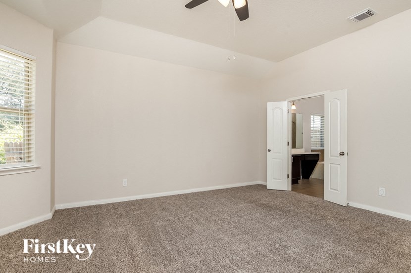 a bedroom with a carpeted floor and a door to a bathroom